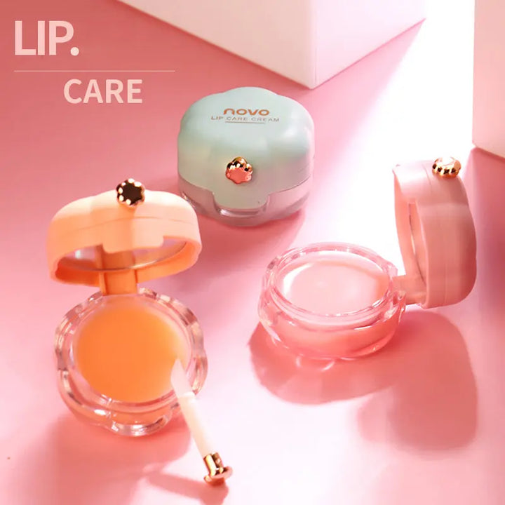 a pink and white box with a pink lid and two small containers of lip care