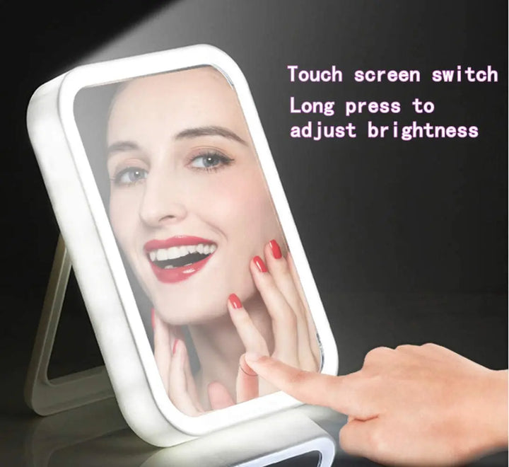 a woman's hand touching her face in front of a lighted mirror